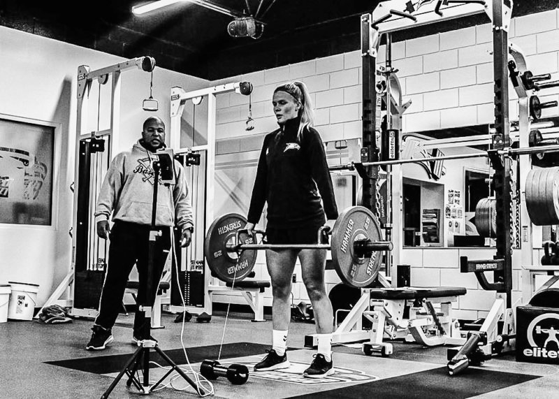 Football athlete training with barbell deadlift